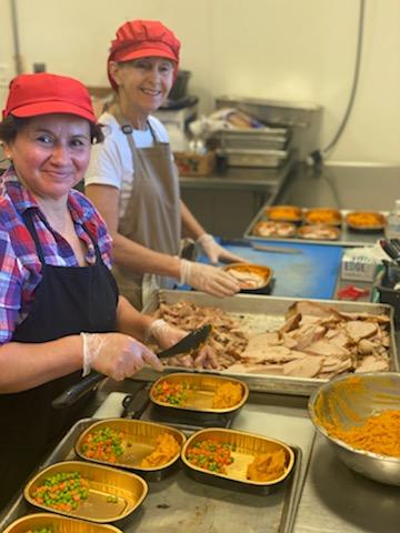 Savory Fare meal delivery service team members prepare Thanksgiving turkey dinners for seniors